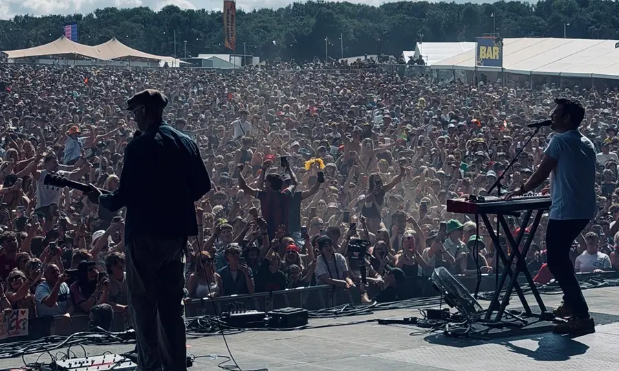 Connor McDonald playing to a large festival crowd under a bright sky