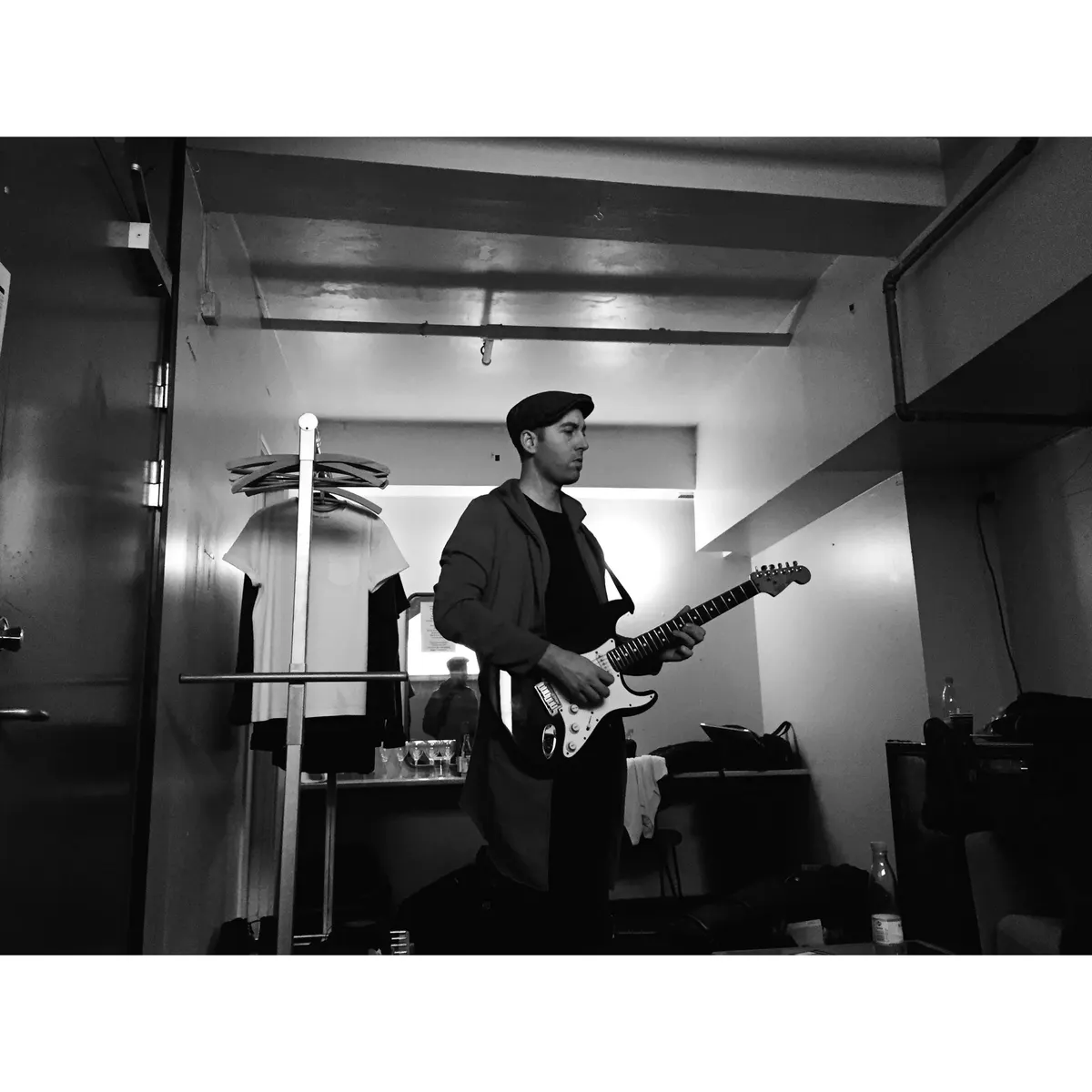 Connor McDonald rehearsing electric guitar in a studio, black and white